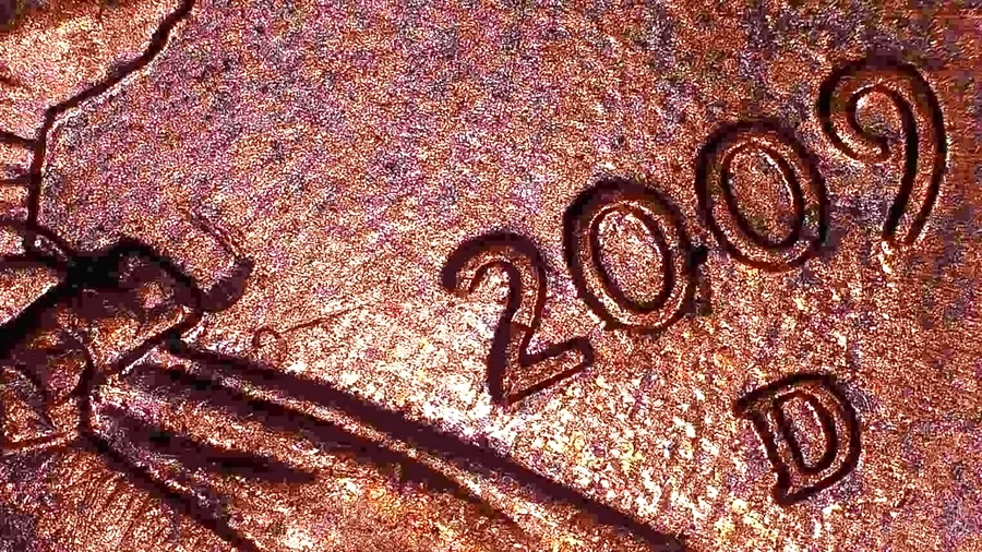The date and D mint mark of a 2009-D Lincoln Bicentennial cent from Jen Mellen's collection, with a nick in the rim beside the D - the kind of spot a case file points at